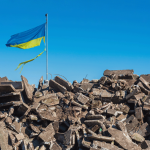 ukraine flag above rubble