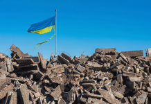 Ukraine Recap: Russia Targets Civilians as the World Argues about How to End the War ukraine flag above rubble