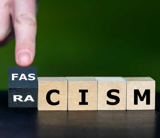 The Rise of Extremist Views in the 21st Century: How Children Are Key to Breaking or Maintaining the Cycle of Violence Cubes form the words racism and fascism. Symbol that racism leads to fascism.